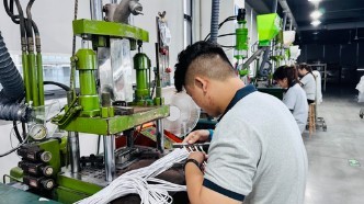 提携工場でケーブルの成形を行う作業員