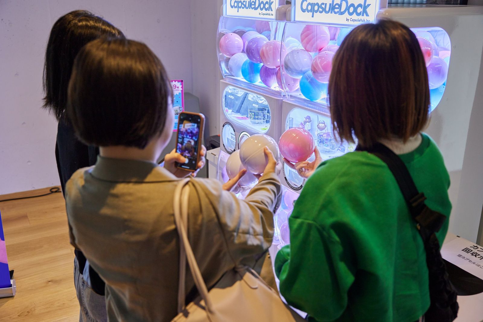 出てきたカプセルをその場でスマートフォンで撮影している様子