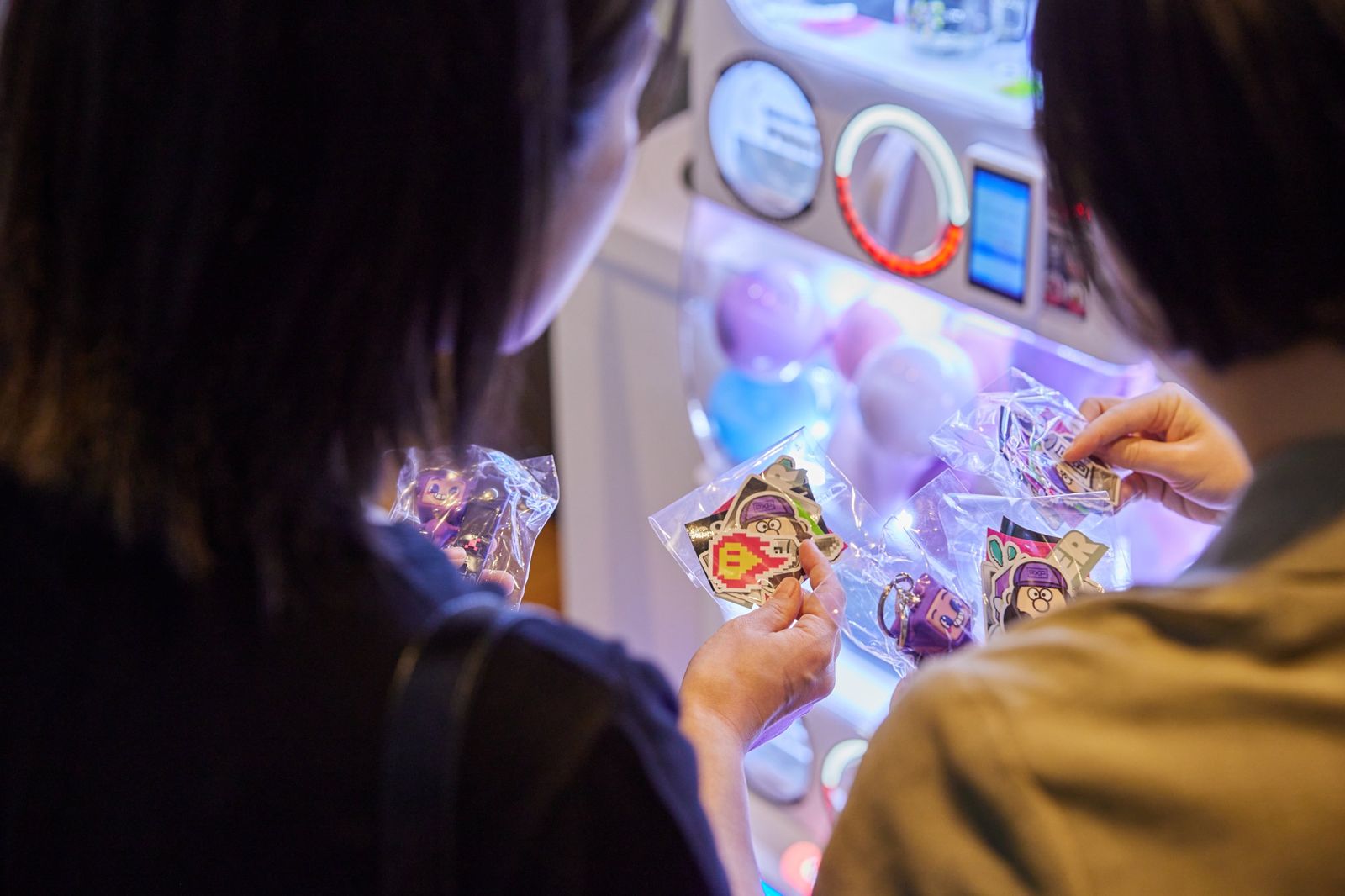 ガチャから出てきたステッカーやキーホルダーを手に取って見ている様子